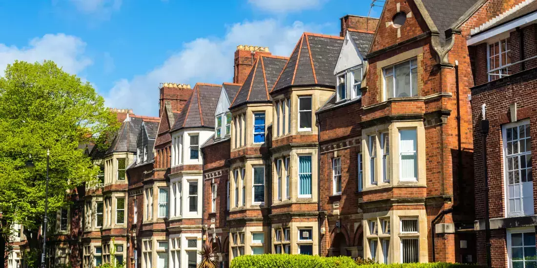 A row of terraced houses in Cardiff against a blue sky backdrop