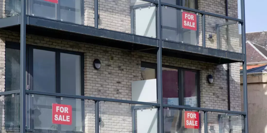 New build flats with for sale signs on their balconies